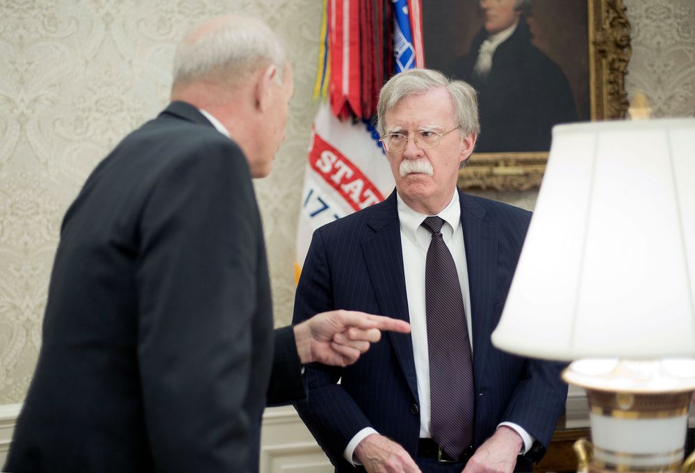 White House Chief of Staff John Kelly, left, talks with, White House National Security Advisor John Bolton, right, in the Oval Office of the White House in Washington during President Donald Trump's meeting to discuss potential damage from Hurricane Michael, Wednesday, Oct. 10, 2018. (AP Photo/Pablo Martinez Monsivais)