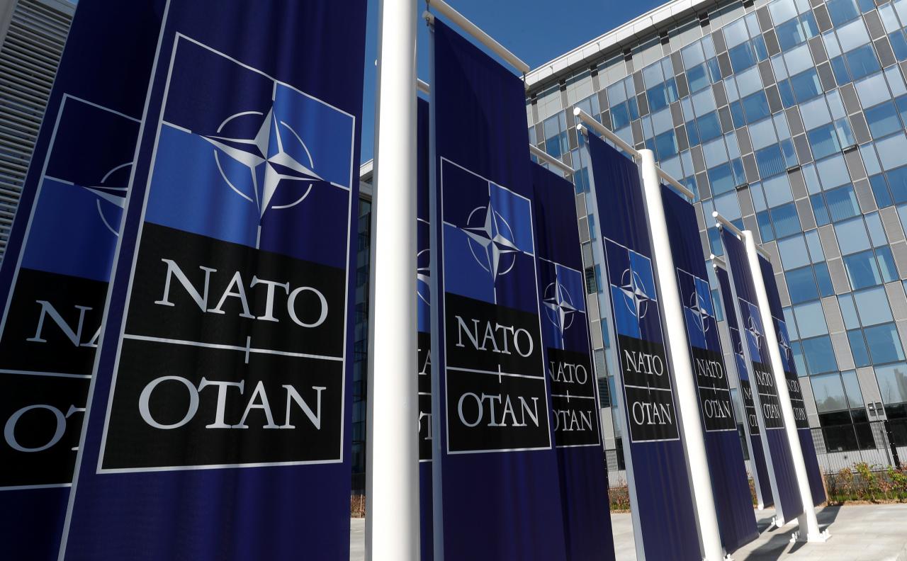 FILE PHOTO: Banners displaying the NATO logo are placed at the entrance of new NATO headquarters during the move to the new building, in Brussels, Belgium April 19, 2018.  REUTERS/Yves Herman