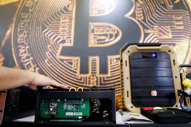 FILE PHOTO:  A cryptocurrency mining computer is seen in front of bitcoin logo during the annual Computex computer exhibition in Taipei, Taiwan June 5, 2018. REUTERS/Tyrone Siu