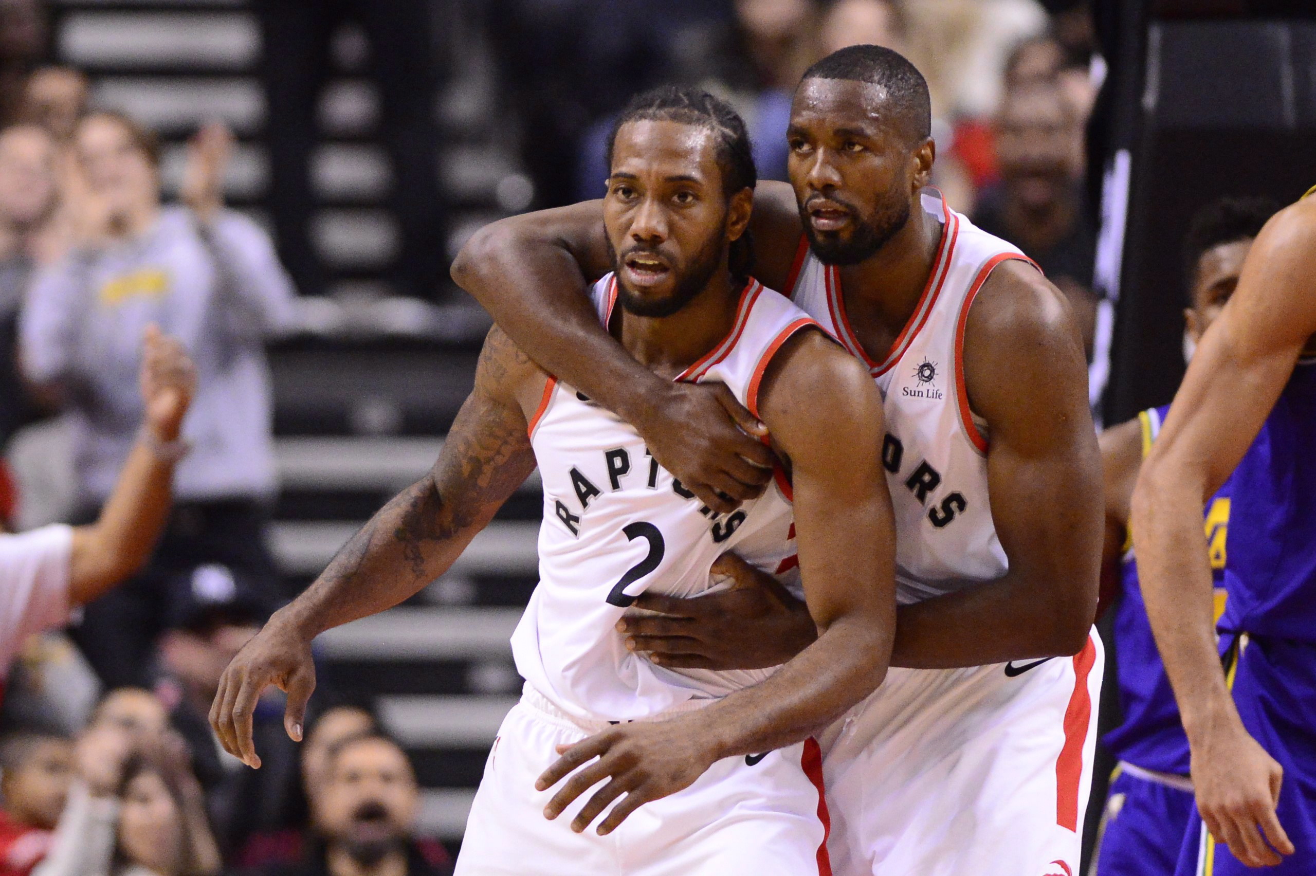 Toronto Raptors forward Serge Ibaka (9) puts his arm around forward Kawhi Leonard (2) after he drew a foul against the Utah Jazz during first half NBA basketball action in Toronto on Tuesday, January 1, 2019. THE CANADIAN PRESS/Frank Gunn