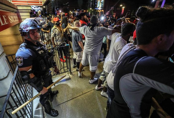 A Group Of Black People Protecting A Cop Who Got Separated From The Others