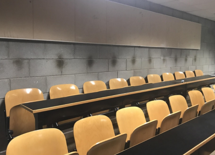 Markings, from people’s heads, on the wall of a lecture hall