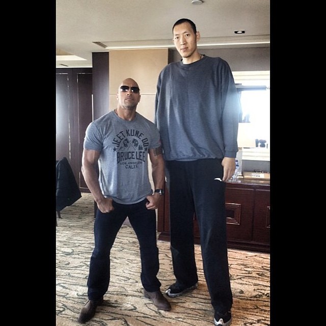 Dwayne Johnson (6’5″) with one of the tallest basketball players in the world, Sun Mingming (7’7″)