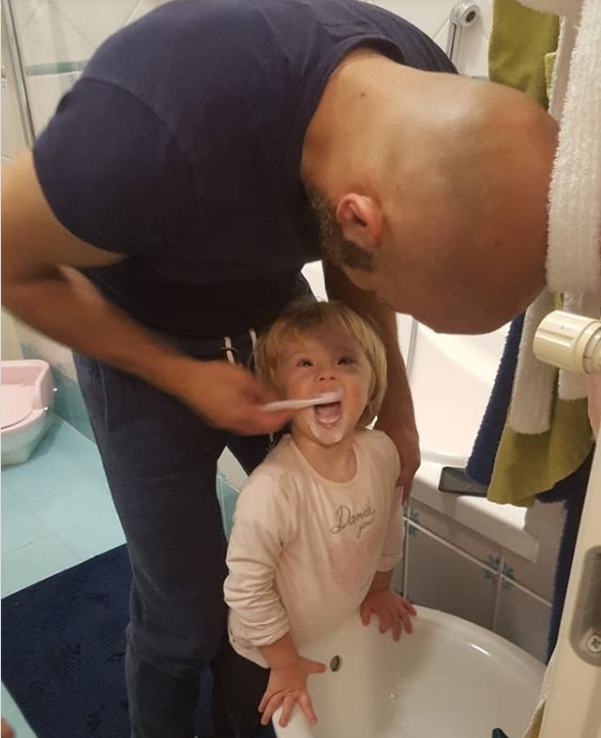 Luca helping Alba in brushing her teeth