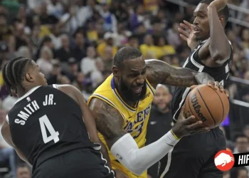 Los Angeles Lakers forward LeBron James, center, drives between Brooklyn Nets guards Dennis Smith Jr. (4) and Lonnie Walker IV, right, during the first half of a preseason NBA basketball game Monday, Oct.